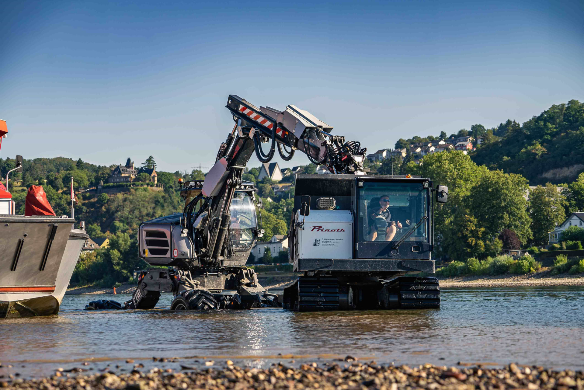 Pinoth-Maschine im Flusseinsatz neben einem Arbeitsschiff