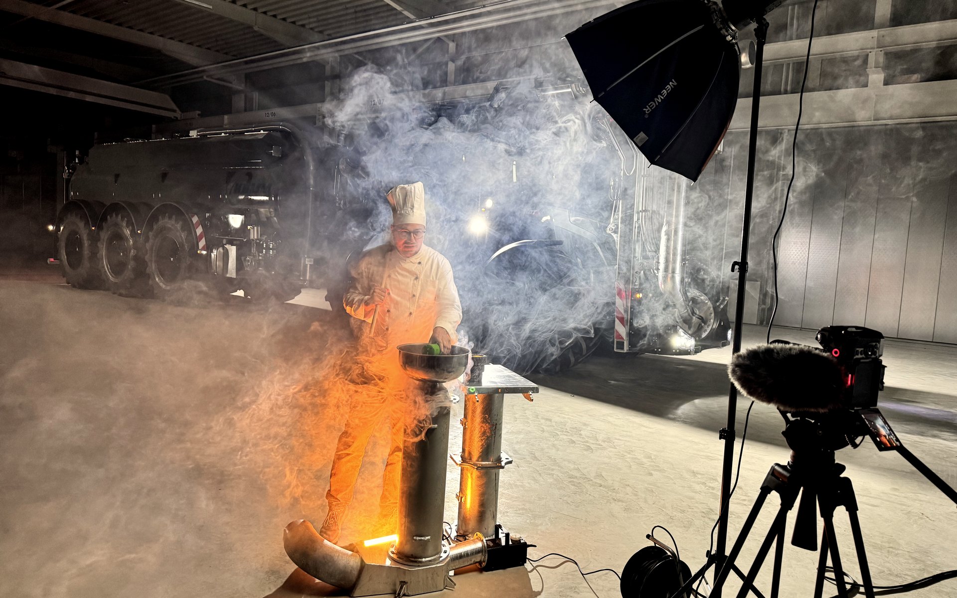 Night shoot inside a hall: softbox, camera on a tripod and a municipal vehicle in the haze